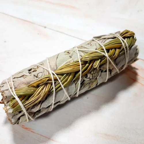 Un atadito de salvia blanca con sweetgrass, hierbas nativoamericanas, sobre un lienzo blanco